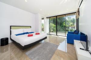 ein Schlafzimmer mit einem Bett und einer blauen Couch in der Unterkunft 3-Story Pool Villa Near Kata Beach - UTK 4 in Kata Beach + 25 Fotos