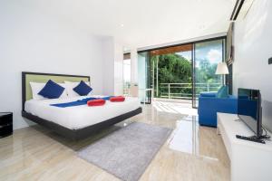 Schlafzimmer mit einem Kingsize-Bett und einem TV in der Unterkunft 3-Story Pool Villa Near Kata Beach - UTK 4 in Kata Beach