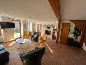ein Wohnzimmer mit Sofa, Stühlen und einem Tisch in der Unterkunft Gîte des Coteaux d'Ebreuil in Ébreuil