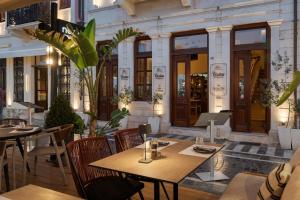 a restaurant with tables and chairs in front of a building at Civitas Suites Hotel in Rethymno