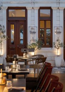 a restaurant with tables and chairs in front of a building at Civitas Suites Hotel in Rethymno +40 photos