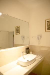 ein Badezimmer mit Waschbecken und großem Spiegel in der Unterkunft Sigiriya Village in Sigiriya