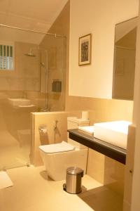 ein Badezimmer mit Toilette, Waschbecken und Dusche in der Unterkunft Sigiriya Village in Sigiriya