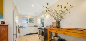 una cucina con un vaso di fiori su un bancone di Hillview Farm - Where the Country meets the Sea! a Yatte Yattah