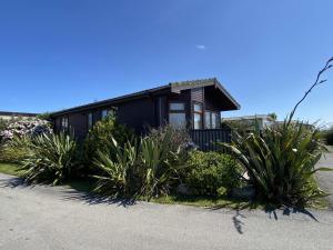a black house with plants in front of it at Lamorna in Penzance