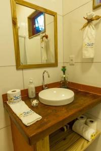 un bagno con lavandino, specchio e asciugamani di Container Vermelho na beira do rio e a poucos metros do mar com cozinha completo a Belmonte