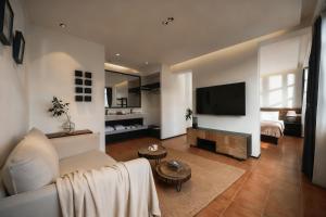een woonkamer met een bank en een flatscreen-tv bij Dongsheng Design Hotel in Dali in Dali