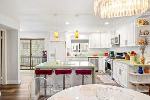 Warner Center Plaza One HeliportにあるElsa Houseのキッチン(白いキャビネット、赤いバースツール付)