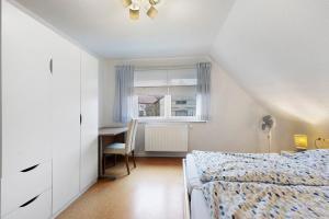 Un dormitorio con una cama y un escritorio y una ventana. en Rosensteinferien, en Mögglingen