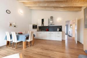 Una cocina y un comedor con mesa y sillas. en Rosensteinferien, en Mögglingen