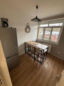 een keuken met een tafel, stoelen en een koelkast bij Les meublés de l Etoile in Eu +17 foto's