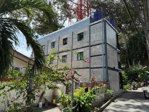 ein graues Gebäude mit Fenstern an der Seite in der Unterkunft Flow Stay Koh Samet I10 流宿沙美島 雙人房 Double room, private bathroom, 2-5mins walk distance to pier and everywhere in Ko Samed