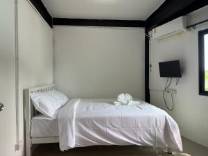 ein Schlafzimmer mit einem weißen Bett und einem Fernseher in der Unterkunft Flow Stay Koh Samet I10 流宿沙美島 雙人房 Double room, private bathroom, 2-5mins walk distance to pier and everywhere in Ko Samed + 3 Fotos