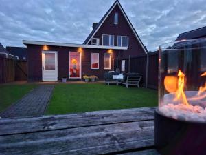 a backyard with a house with a fire in a glass jar at B&B De Terpen in Dokkum