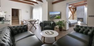 ein Wohnzimmer mit schwarzen Ledermöbeln und einem Tisch in der Unterkunft Kaiserstein Palace Apartments in Prag