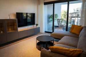 a living room with a couch and a flat screen tv at Luxe One Residence in Aglantzia