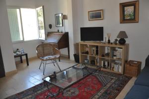 a living room with a couch and a table and a television at Les Moineaux in Rustrel