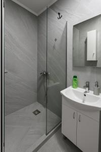 um banheiro com chuveiro e pia em 3 Stars Apartments em Prilep