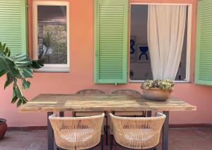 a wooden table with chairs and a potted plant on a patio at Il giardino di Gaia in Portoferraio +49 photos