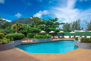 a swimming pool in a resort with umbrellas at Phuket Merlin Hotel in Phuket Town