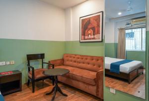 una habitación con un sofá y una cama y una mesa en Olive Zip Rest House Road by Embassy Group, en Bangalore 43 fotos más