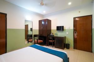Un dormitorio con una cama, un escritorio y un espejo. en Olive Zip Rest House Road by Embassy Group, en Bangalore