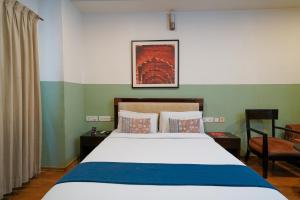 un dormitorio con una cama y una silla en Olive Zip Rest House Road by Embassy Group, en Bangalore 42 fotos más