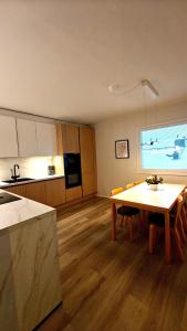 a kitchen and living room with a table and chairs at Bright Elegant - Feel Lapland with light & harmony in Rovaniemi