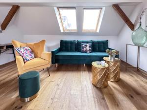 ein Wohnzimmer mit einem blauen Sofa und 2 Stühlen in der Unterkunft Rebenglück in Rohrendorf bei Krems + 3 Fotos