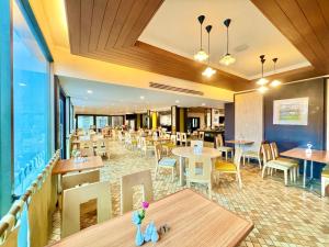 a restaurant with tables and chairs and a cafeteria at Phuket Merlin Hotel in Phuket Town