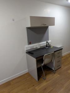 einen Schreibtisch mit Stuhl in einem Zimmer in der Unterkunft Modern Studio Apartment in Central Newcastle in Central Station