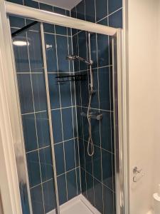 eine Dusche in einem Badezimmer mit blauen Fliesen in der Unterkunft Modern Studio Apartment in Central Newcastle in Central Station