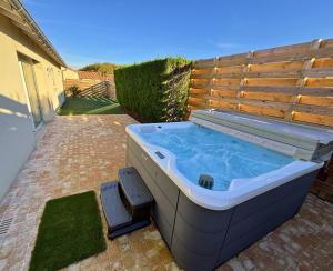 Ein Whirlpool mit zwei Hockern steht im Garten. in der Unterkunft Maison cosy - Logis Flo - à 15 min du Futuroscope in Beaumont