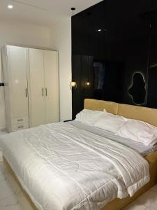 a bedroom with a large white bed with white pillows at Shortletbylolami in Mama +12 photos