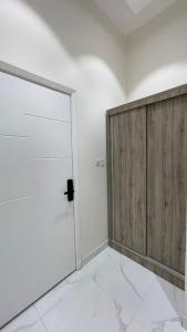 a white room with a wooden door in it at غرفه - واڤا in Tabuk
