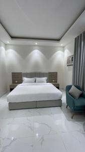 a bedroom with a bed and a blue chair at غرفه - واڤا in Tabuk