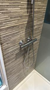 a close up of a shower door with a hose at A 15 min de l'entrée de Bruxelles in Rixensart