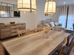 a dining room and living room with a wooden table at Lybica Green "Enclavament de Llívia" in Llivia