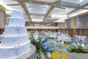 a wedding cake in a banquet hall with tables and chairs at Phuket Merlin Hotel in Phuket Town +72 photos