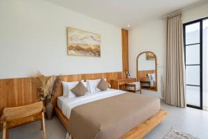 a bedroom with a large bed and a table at Tanahlot Beachview Rooftop Villa in Tanah Lot +19 photos