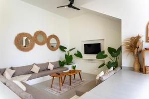 a living room with a couch and a table at Tanahlot Beachview Rooftop Villa in Tanah Lot