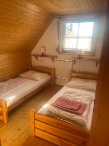 利普托斯基米库拉斯Liptovské Drevenice-chaty的木间设有两张床,设有窗户