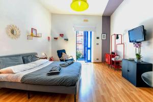 a bedroom with a bed and a flat screen tv at La stanza Modicana in Modica