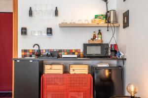 a kitchen with a black refrigerator and a microwave at La stanza Modicana in Modica