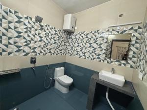 a bathroom with a toilet and a sink at Ekatma Stays - Farm & Homestay, Kakrighat in Shitlakhet +75 photos