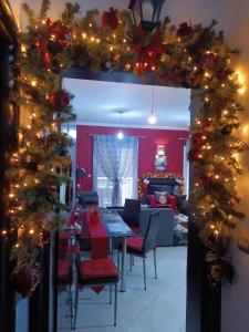 een eetkamer met kerstverlichting en een eettafel bij RnB Red&Black in Nafpaktos