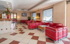 a living room with red couches and a table at Best Western Hotel I Triangoli in Casal Palocco