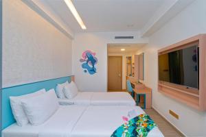 una habitación de hotel con dos camas y un televisor de pantalla plana en h78 Guraidhoo, en Guraidhoo