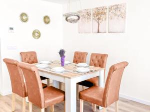 einen Esstisch mit 4 Stühlen und einem weißen Tisch in der Unterkunft Entire Villa Private Sea-View Villa in Finestrat in Finestrat