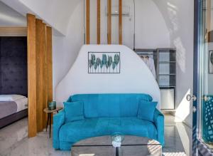 Una sala de estar con un sofá azul y una cama. en Oia Suites, en Oia 146 fotos más